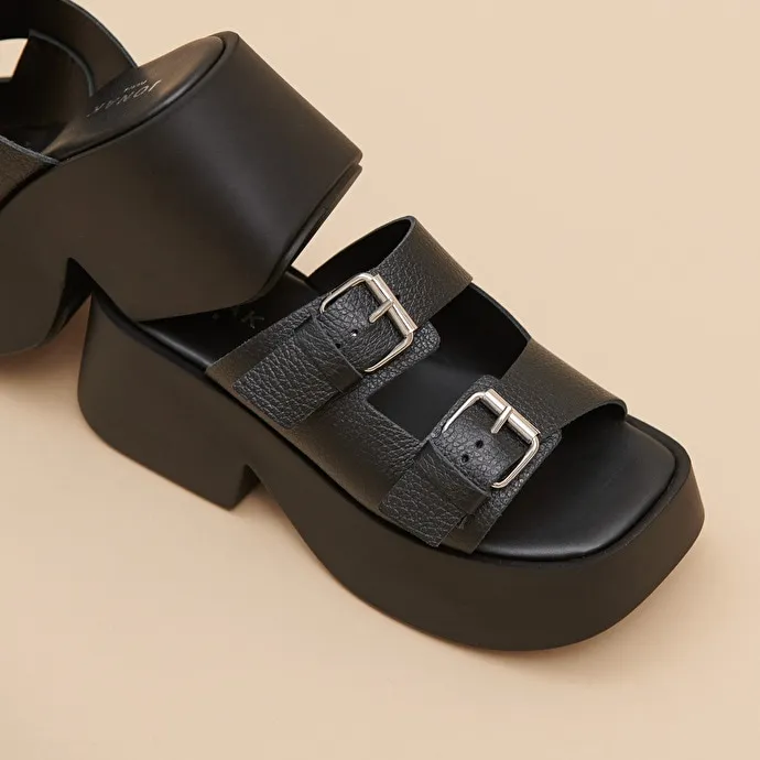 Mules with thick straps, buckles and open toes in black grained leather