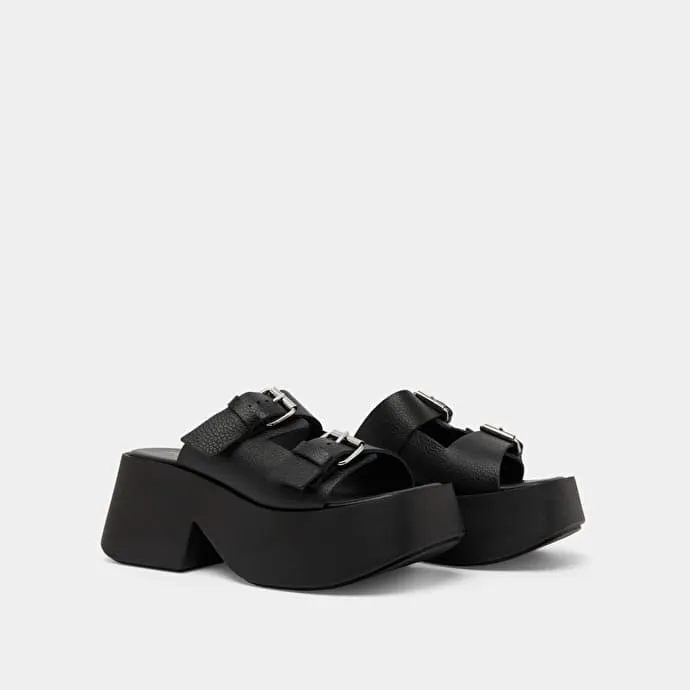 Mules with thick straps, buckles and open toes in black grained leather