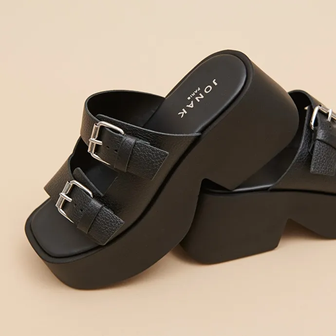 Mules with thick straps, buckles and open toes in black grained leather