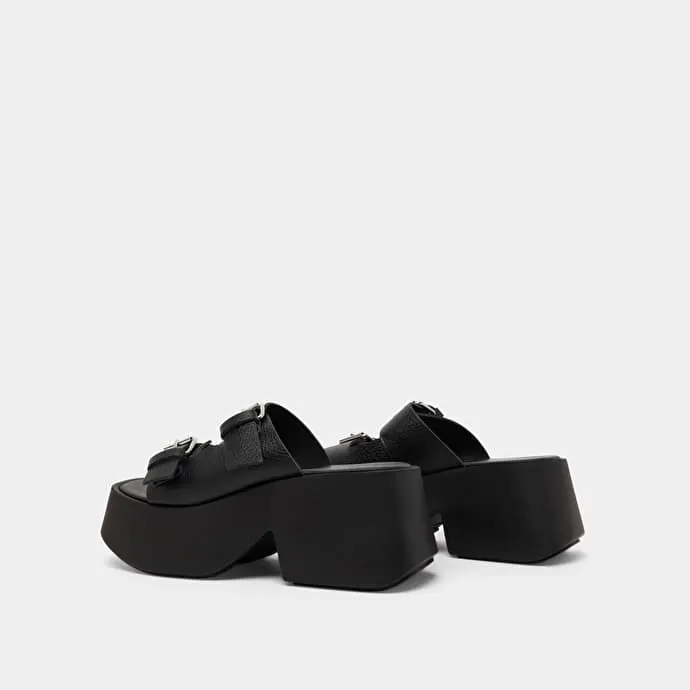 Mules with thick straps, buckles and open toes in black grained leather